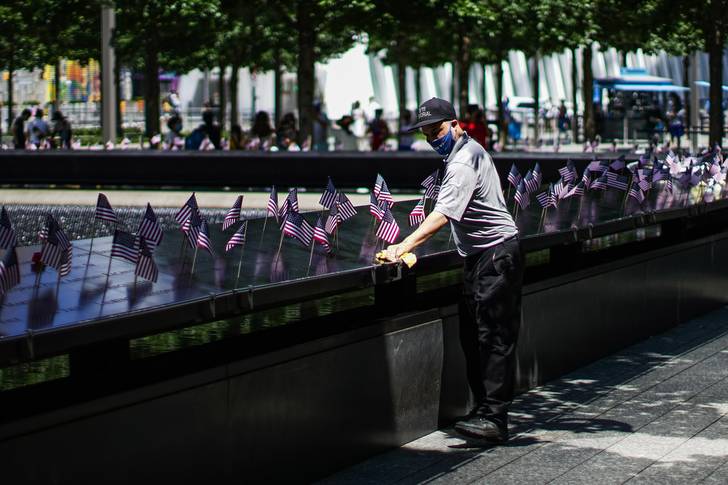 A worker uses a cloth to clean the memorial.